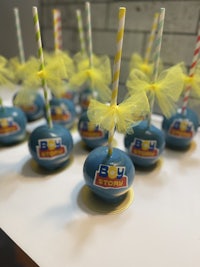 a group of blue and yellow cake pops on a table